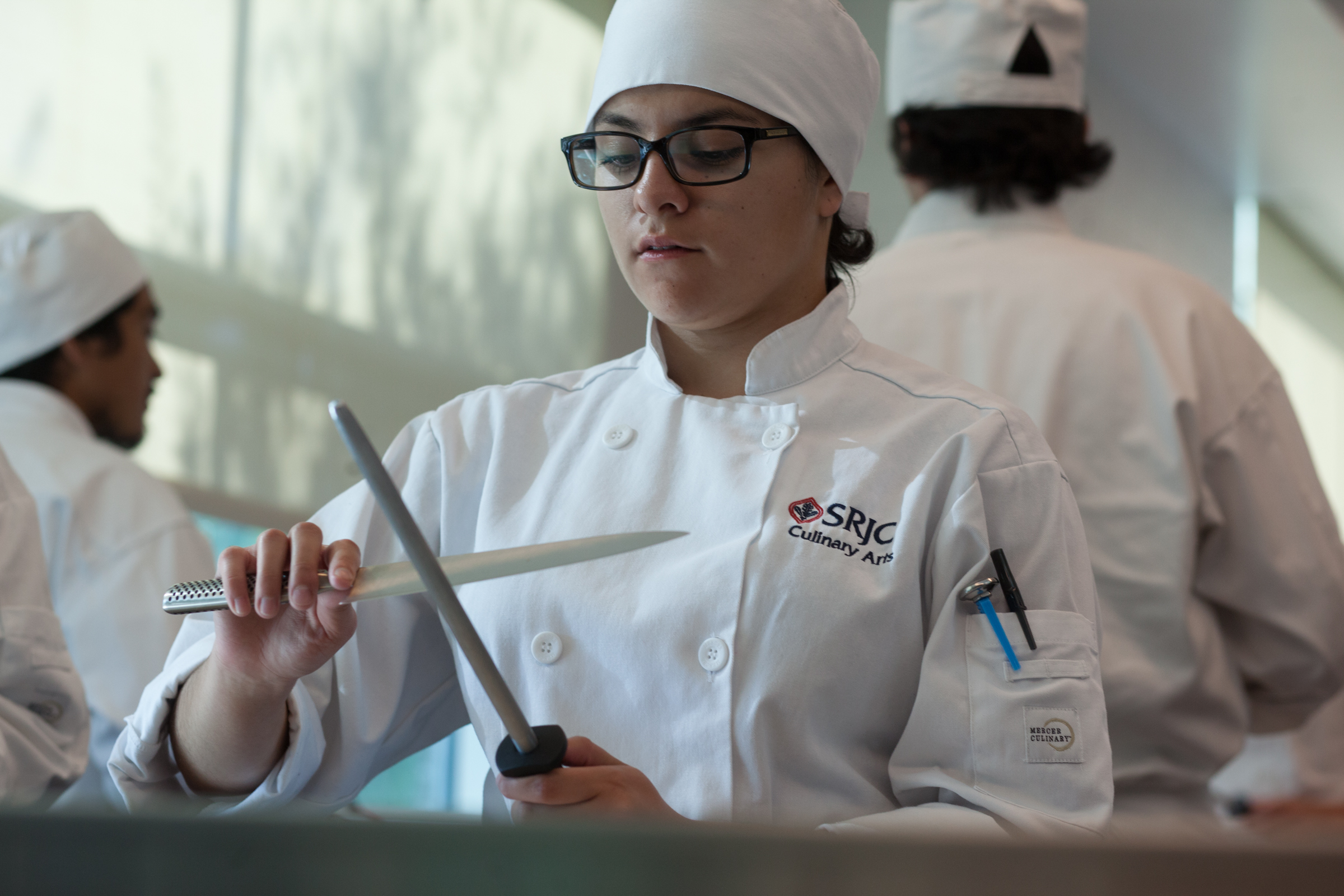 Culinary student sharpening a knife