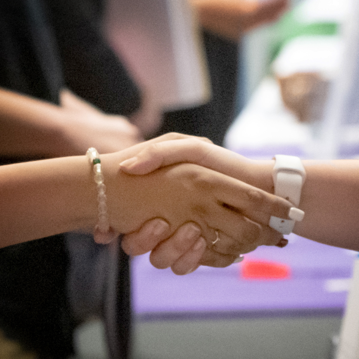 A cropped view of an employer's hand shaking a student's hand. 